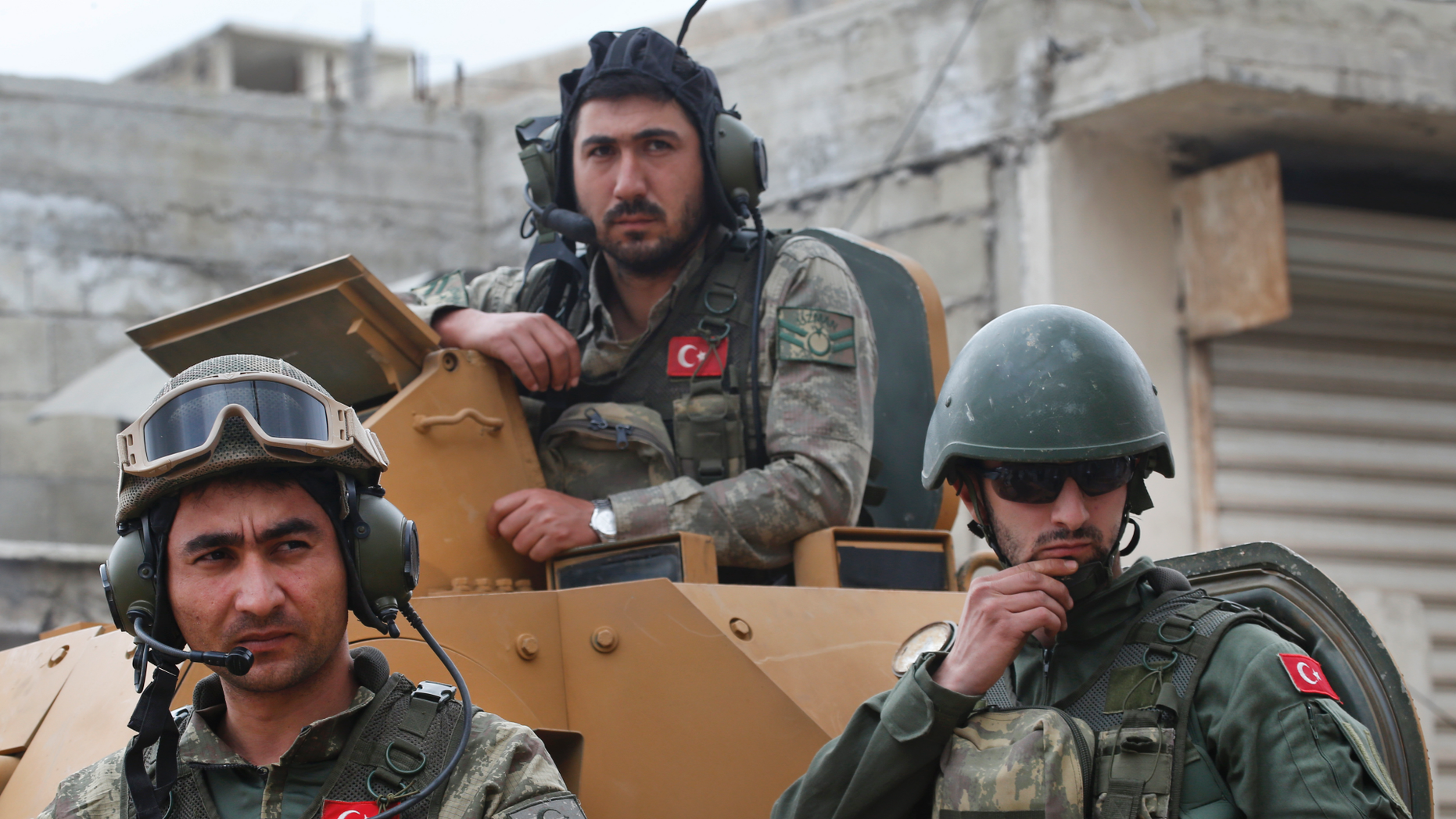 FILE - In this March 24, 2018 file picture Turkish soldiers on top of an armored personnel carries safe streets in the northwestern city of Afrin, Syria, under a Turkish state-organized media tour in northern Syria. Turkish military said Sunday, March. 31, 2019, that one of his soldiers has been killed in Syria north in which Syrian activists describe as an attack by local Kurdish warriors. Turkey's Ministry of Defense said a mortar attack Sunday on its troops around Afrin in northwest Syria killed a soldier and injured another. (AP Photo / Lefteris Pitarakis, File)